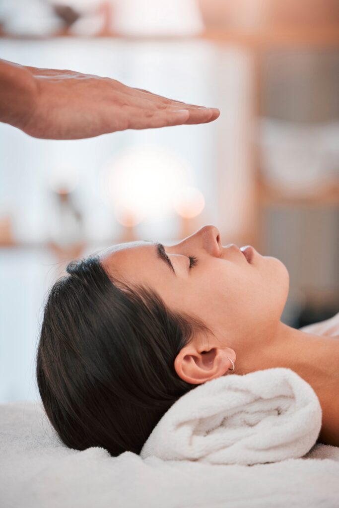 Reiki, hand and woman at a spa for relax, reiki healing and energy balance, peace and stress relief